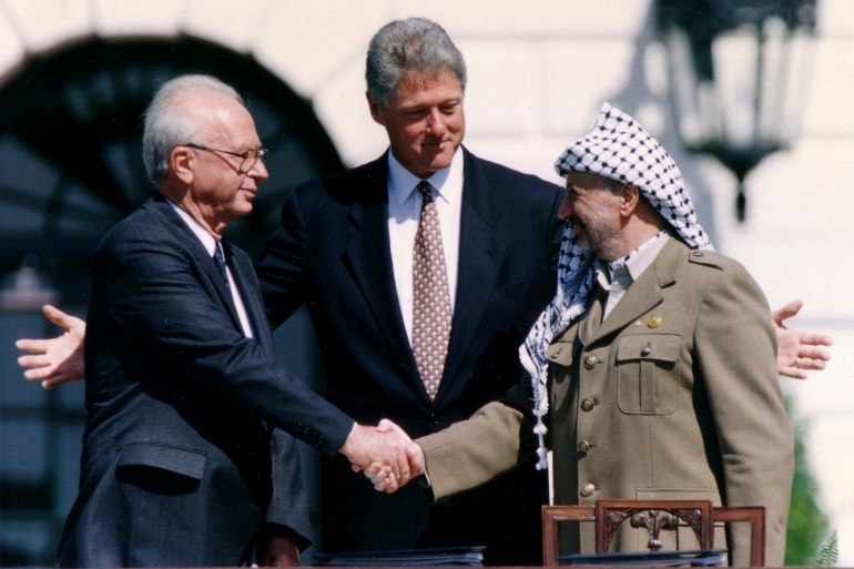 PLO Chairman Yasser Arafat (R) shake hands with Israeli Prime Minister Yitzhak Rabin (L), as U.S. President Bill Clinton stands between them, after the signing of the Israeli-PLO peace accord, at the White House in Washington September 13, 1993. REUTERS/Gary Hershorn (UNITED STATES - Tags: POLITICS)