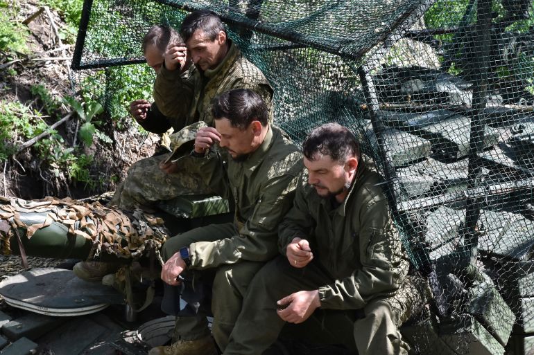This handout picture taken and released by press-service of the 65th Separate Mechanised Brigade shows Ukrainian servicemen taking part in Easter service lead by Chaplain Father Sergiy in Zaporizhzhya region on April 20, 2025, amid the Russian invasion of Ukraine.