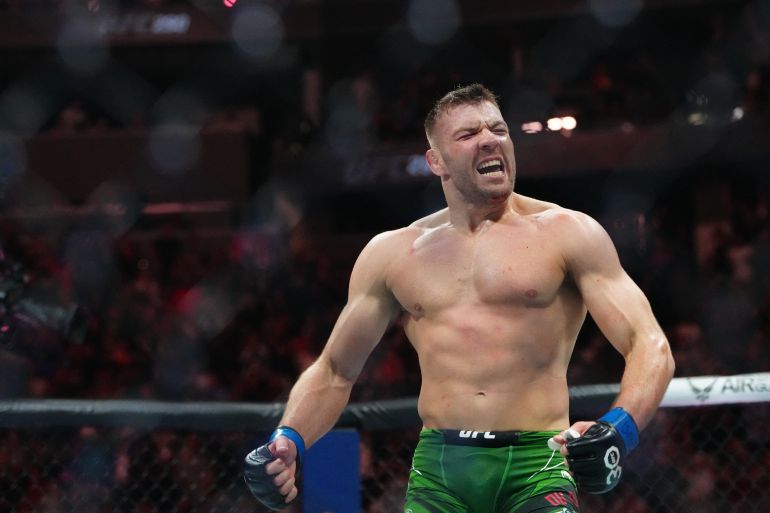 Jul 8, 2023; Las Vegas, Nevada, USA; Dricus Du Plessis (blue gloves) reacts after defeating Robert Whittaker (red gloves) during UFC 290 at T-Mobile Arena. Mandatory Credit: Stephen R. Sylvanie-USA TODAY Sports